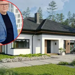 Mężczyzna w garniturze obok nowoczesnego domu jednorodzinnego. Dowiedz się, ile kosztuje budowa małego domu jednorodzinnego.