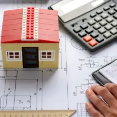 Planowanie budowy domu 130m2: model domu, kalkulator, szkice i notatki.