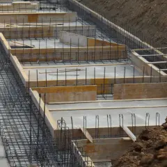 Szkielet zbrojeniowy i szalunki drewniane czekają na beton. Tak wygląda budowa fundamentów krok po kroku.