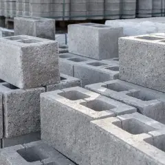 Stos szarych bloczków fundamentowych. Zastanawiasz się, ile bloczków fundamentowych na metr kwadratowy potrzebujesz do budowy?
