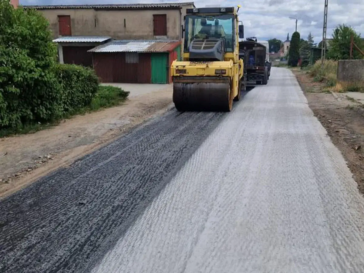 Walec drogowy ubija świeży asfalt. Zastanawiasz się, ile kosztuje kilometr asfaltu? Prace drogowe w toku.